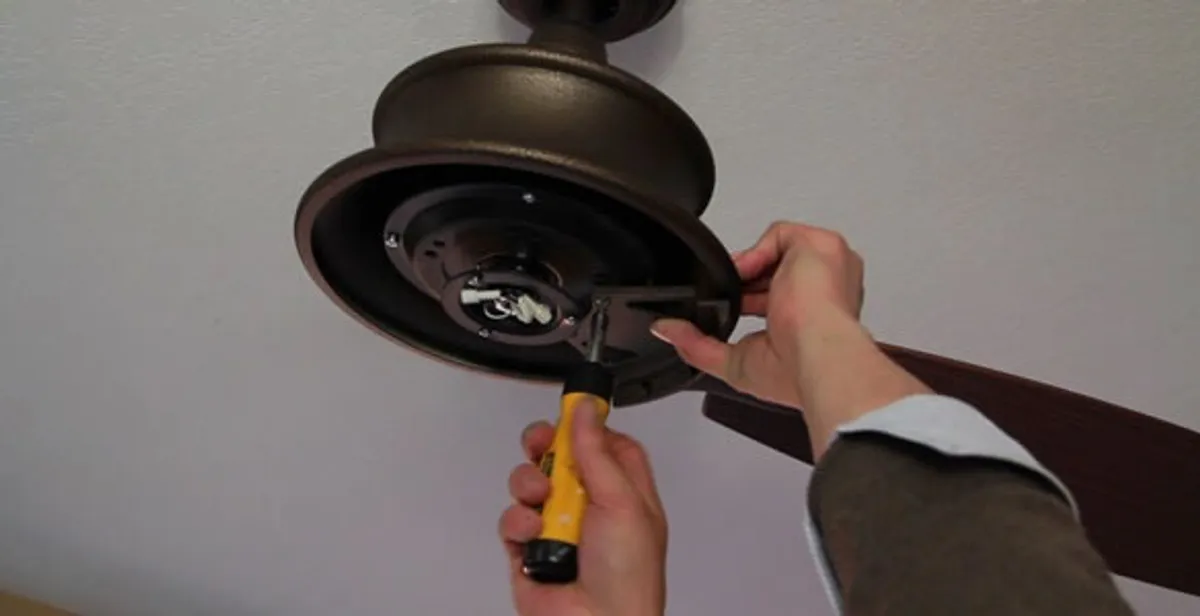 Electrician installing ceiling fan mounting bracket and fixture in Detroit, MI